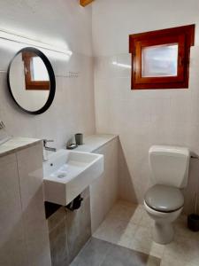 ein Badezimmer mit Waschbecken, Toilette und Spiegel in der Unterkunft Oliveto e mare in Syvota + 35 Fotos
