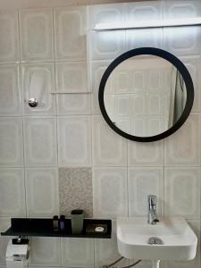 a white bathroom with a sink and a mirror at Oliveto e mare in Syvota