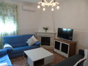 ein Wohnzimmer mit einem blauen Sofa und einem TV in der Unterkunft Casa El Molino in Montecorto