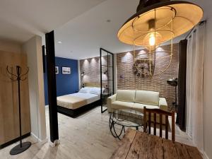 1 dormitorio con cama, sofá y mesa en Aparthotel Luz de Gades - Suites Spa Gym - Adults Only, en Cádiz
