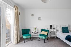 a bedroom with a bed and two chairs and a table at Number 4 - Lytton Tree Lodge, Reydon, Southwold in Reydon