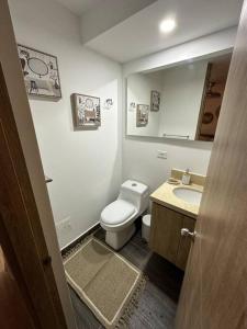 ein Badezimmer mit einem WC, einem Waschbecken und einem Spiegel in der Unterkunft New, cozy & stylish apartment in Armenia