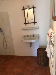 a bathroom with a sink and a trash can at Un cabanon en Provence in Auriol