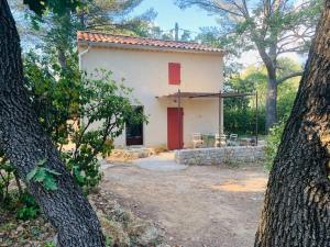 a small white house with a red door at Un cabanon en Provence in Auriol