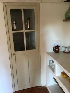 a white door in a room with a shelf at Un cabanon en Provence in Auriol