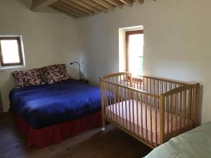 a bedroom with a bed and a crib and a window at Un cabanon en Provence in Auriol