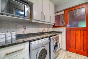a kitchen with a washing machine and a sink at San Lameer Villa 2513 by Top Destinations Rentals in Southbroom