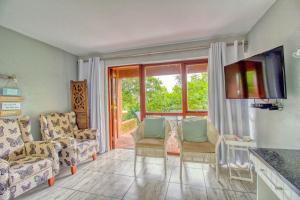 a living room with a couch and chairs and a television at San Lameer Villa 2513 by Top Destinations Rentals in Southbroom