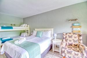 1 dormitorio pequeño con 1 cama y 1 silla en San Lameer Villa 2513 by Top Destinations Rentals en Southbroom