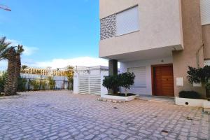 a house with a driveway in front of a building at Villa ilian in Monastir