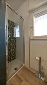 uma cabina de duche em vidro numa casa de banho com uma janela em La Casetta a Santa em Santa Marinella
