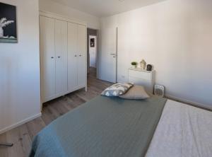 ein Schlafzimmer mit einem großen Bett und weißen Wänden in der Unterkunft La Casetta a Santa in Santa Marinella