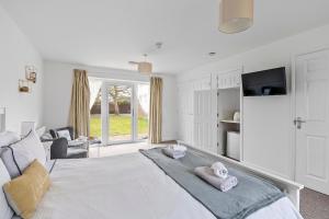 a bedroom with a large white bed with towels on it at Number 5 - Lytton Tree Lodge, Reydon, Southwold in Reydon