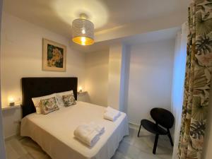 1 dormitorio pequeño con 1 cama y 1 silla en Apartment with solarium/terrace., en Calpe