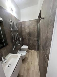 a bathroom with a white sink and a toilet at Cinque Terre HUB LUXURY HOME IN LA SPEZIA in La Spezia