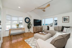 sala de estar con sofá y TV en CbytheSea - Ocean View Penthouse, en Gloucester