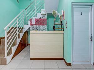 pasillo con escalera y puerta blanca en OYO 92521 Guest House Inayah Syariah en Yogyakarta