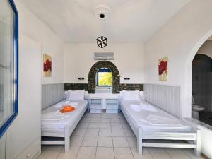 a room with two beds and a table at Pavlis Studios Ormos in Marathokampos