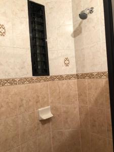 um chuveiro com uma cabeça de chuveiro preta na casa de banho em Suite Antequera en mexico em Oaxaca de Juárez