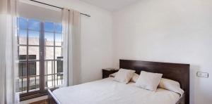 a bedroom with a bed and a large window at Residencial Maresia el Medano in El Médano