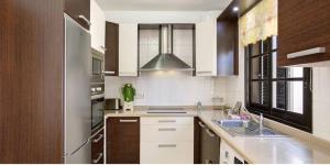 a kitchen with a sink and a stove at Residencial Maresia el Medano in El Médano