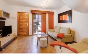 a living room with a couch and a tv at Residencial Maresia el Medano in El Médano