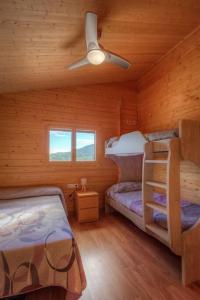 a bedroom with two bunk beds in a wooden cabin at Villa Vilosa - Anna in Anna