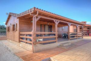 a small wooden cabin with a porch on a patio at Villa Vilosa - Anna in Anna