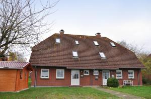 una gran casa de ladrillo rojo con techo marrón en Petersdorf Ferienwohnung Kleine Auszeit, en Westfehmarn