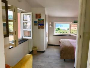 sypialnia z łóżkiem i 2 oknami w obiekcie Agriturismo Terre Rosse Portofino w Protofino