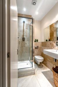 a bathroom with a shower and a toilet and a sink at Cozy Covent Garden/Oxford Street apartment in London