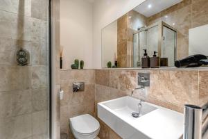 a bathroom with a sink and a toilet and a shower at Cozy Covent Garden/Oxford Street apartment in London