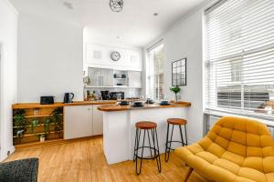 a kitchen with a counter and stools in a room at Cozy Covent Garden/Oxford Street apartment in London