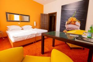 MÖRWALD Grafenegg Hotel في Grafenegg: غرفة فندقية بسرير وطاولة وكراسي