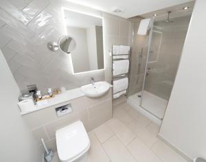 La salle de bains est pourvue de toilettes, d'un lavabo et d'une douche. dans l'établissement The Angel Hotel, à Leamington Spa