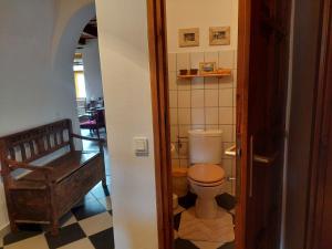 a bathroom with a toilet and a chair in a room at Patak Üdülőház (Ferienhaus) in Nagyvisnyó +51 photos