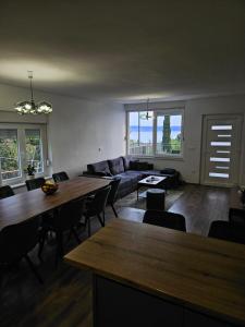 a living room with a couch and tables and windows at Modern Seaview House Fiore in Starigrad-Paklenica