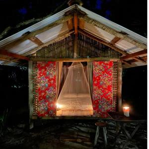 una casa de aves con dosel y mesa en Cabana Caiçara Praia do Sono Paraty RJ en Parati