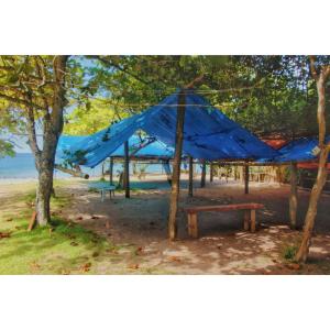 ein blaues Zelt am Strand mit einem Picknicktisch in der Unterkunft Cabana Caiçara Praia do Sono Paraty RJ in Paraty