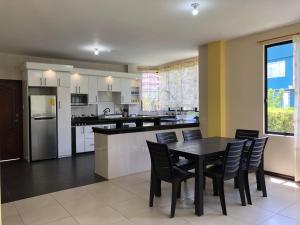 a kitchen with a black table and chairs in it at Family house/casa de Familia 3 bedroom 3 bath in Baños