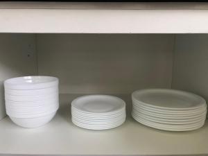 three white plates sitting on a shelf in a cabinet at Family house/casa de Familia 3 bedroom 3 bath in Baños