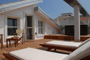 a patio with two beds and a television on a deck at Atmosfere Milano Marittima in Milano Marittima