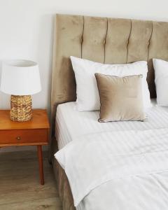 a bed with white pillows and a lamp on a table at Bella Vista Cheia in Cheia