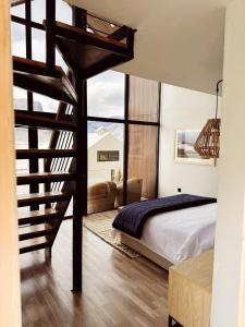 a bedroom with a loft bed and a spiral staircase at Khoj Resorts in Shigar