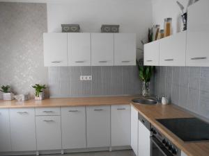 a kitchen with white cabinets and a sink at Mavi appartman in Nagykanizsa