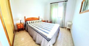 sypialnia z łóżkiem, oknem i lustrem w obiekcie Dúplex 3 Dormitorios VERAMAR 5 Vera Playa primera línea de playa con vistas al mar w mieście Vera