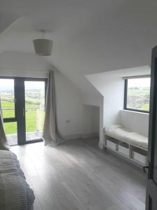 a white room with a bed and a window at The Hideaway Tragumna a hidden gem in the hills in Drishanebeg