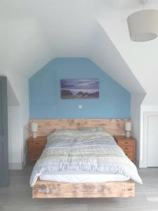 a bedroom with a bed with a blue wall at The Hideaway Tragumna a hidden gem in the hills in Drishanebeg
