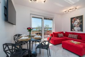 a living room with a red couch and a table at Infinity Residence in Trogir