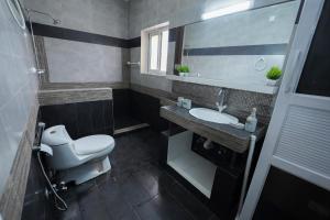 a bathroom with a toilet and a sink and a mirror at SK Residence in Islamabad